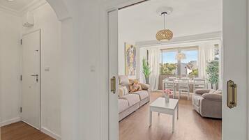 A spacious living room with a sofa, coffee table, and dining area.