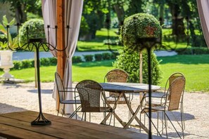 An outdoor patio with a table and chairs, surrounded by greenery and a well-maintained garden. - Le Manoir du Thouron (Saint-Sulpice-la-Pointe)