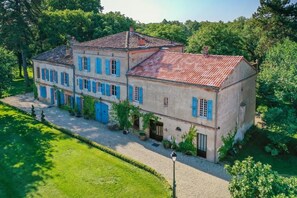 A two-story building with a symmetrical facade, a gravel driveway, and a well-maintained garden. - Le Manoir du Thouron (Saint-Sulpice-la-Pointe)