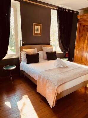 A bedroom with a bed, a bedside table, a window, and a door. - Le Manoir du Thouron (Saint-Sulpice-la-Pointe)