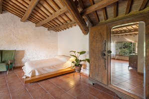 A room with a bed, a potted plant, and a large mirror. - Rural House 'El Masot de Durban' with Mountain Views, Private Terrace and Wi-Fi (Montfalcó Gros)