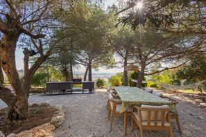 An outdoor seating area with a table and chairs, surrounded by trees and a view of the landscape. - Rural House 'El Masot de Durban' with Mountain Views, Private Terrace and Wi-Fi (Montfalcó Gros)