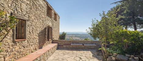 A stone building with a stone pathway leading to a scenic overlook.