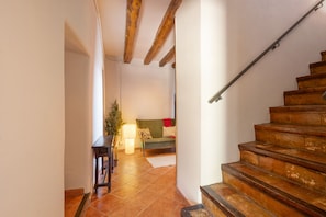 A staircase leading to a living area with a sofa and a lamp.