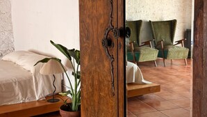 Ein Zimmer mit Holzschrank, Bett und Topfpflanze, mit Blick auf ein rustikales Interieur.