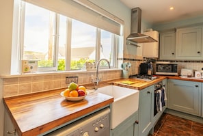A kitchen with a wooden countertop, a sink, a stove, and cabinets. - Dog Friendly Dorset Escape for 2 (Swanage)