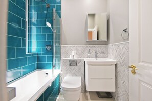 A bathroom with a bathtub, toilet, and sink. - Spacious & stylish 2 bedroom apartment in Kentish Town (London)