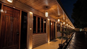 Un edificio con fachada de madera, varias puertas y una hilera de luces colgantes.
