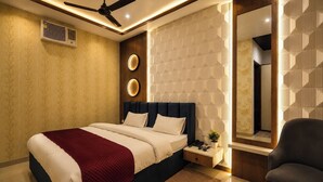 A modern bedroom with a bed, bedside table, and a chair. - The Gautam Resort (Varanasi)