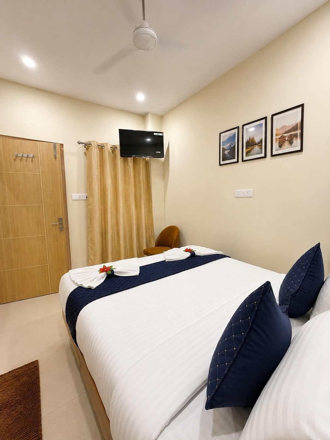 Une chambre d’hôtel avec un lit, un téléviseur fixé au mur et une porte.