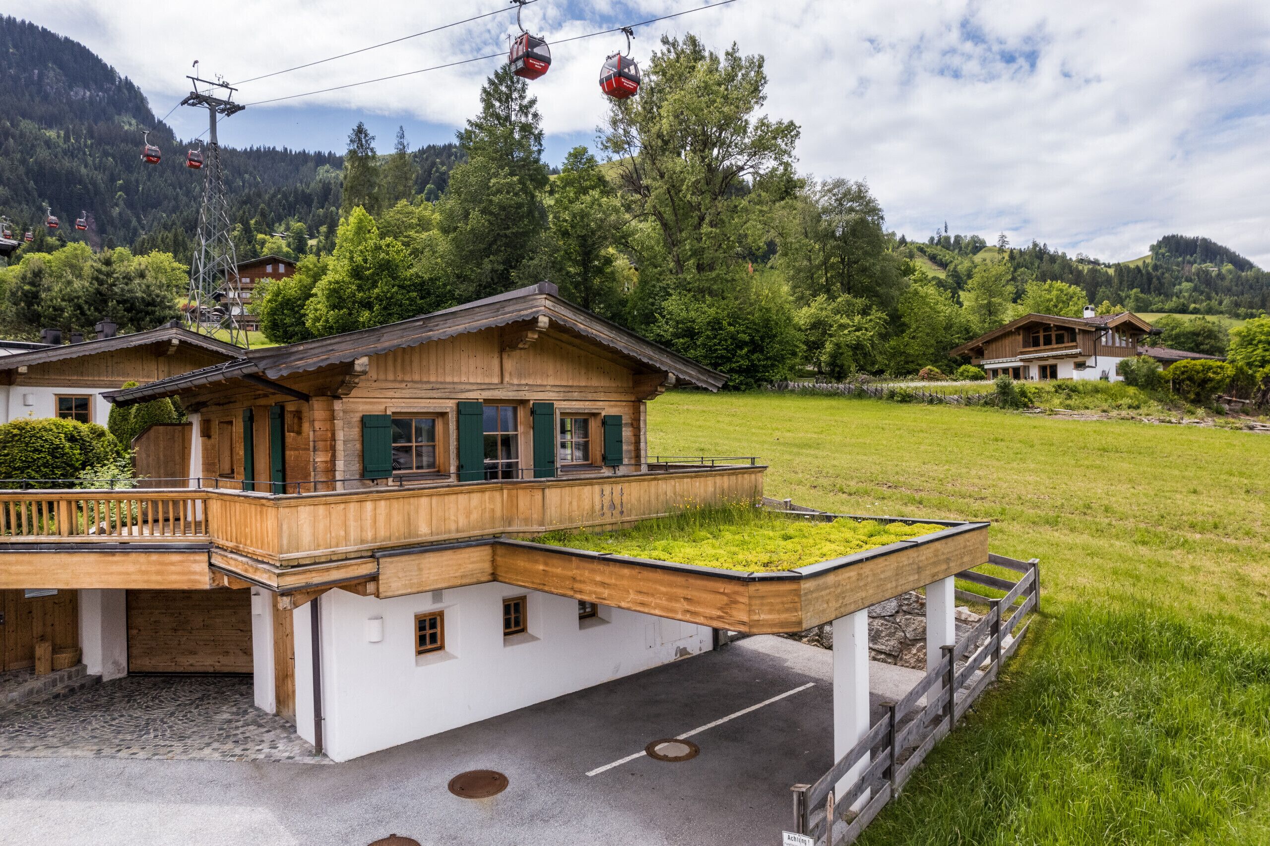 Un chalet traditionnel doté d’un balcon en bois et d’un petit jardin.