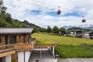 Eine Berghütte mit Holzfassade, einem Balkon und Blick auf ein Gebirge.