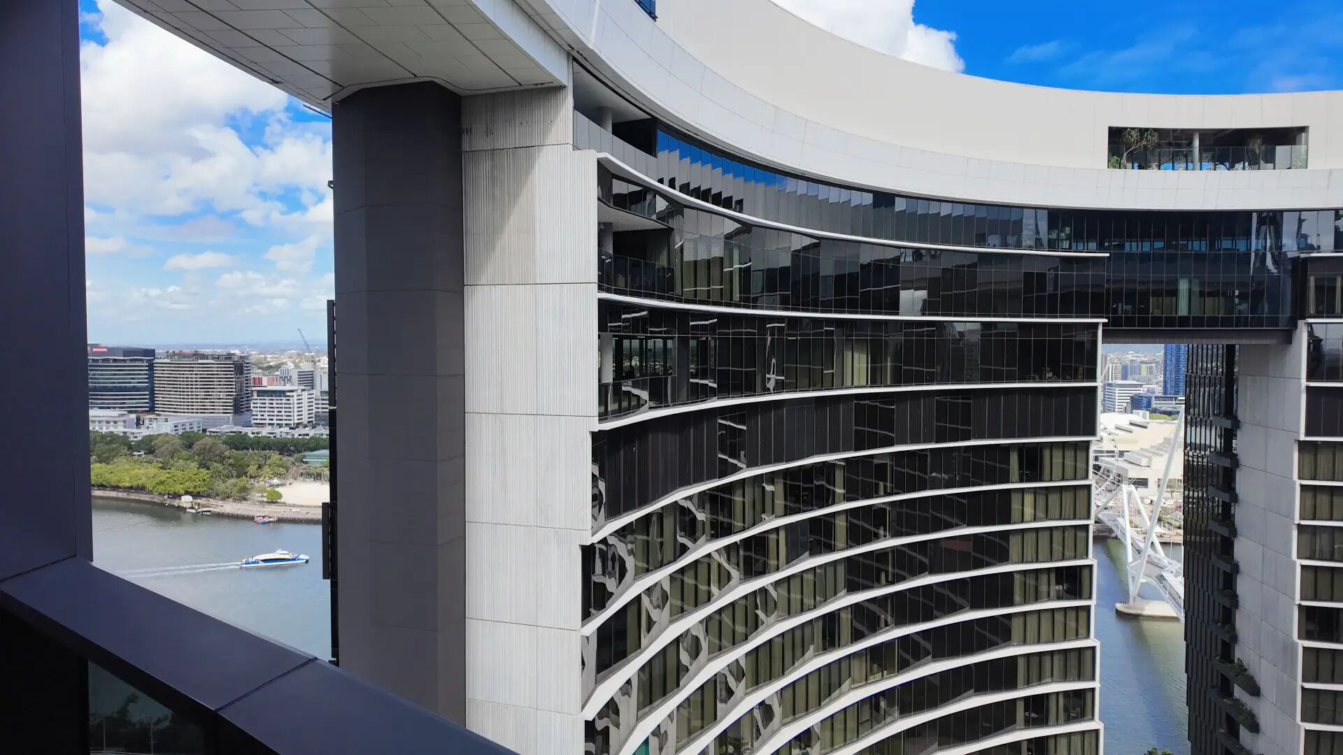 Un bâtiment moderne doté d’une façade incurvée et de nombreux balcons.