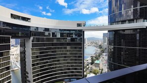 Un edificio moderno con facciata curva, ampie finestre e vista sulla città e sul corpo d'acqua.