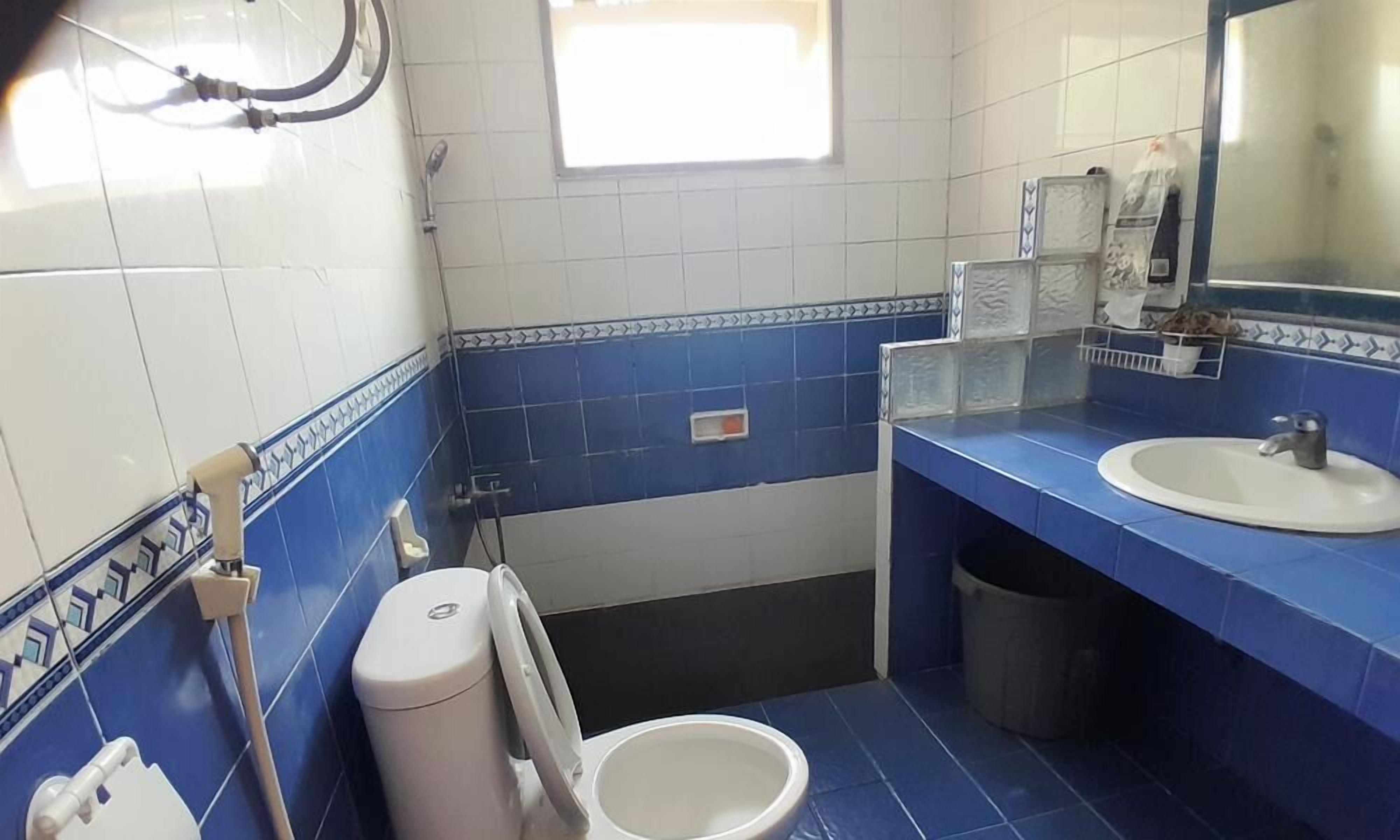 Un baño con inodoro, bidé, lavabo y espejo.