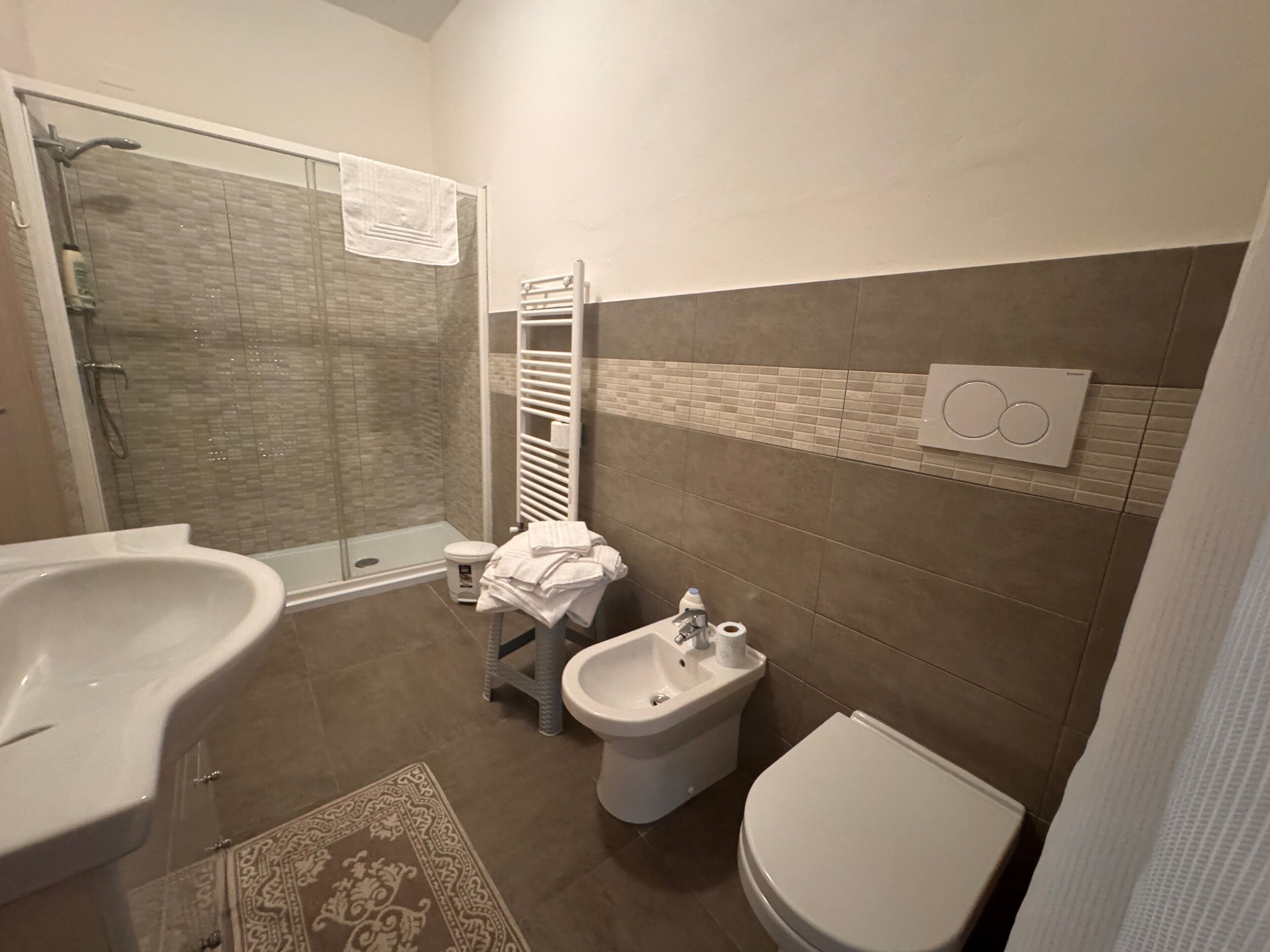 Ein Badezimmer mit Dusche, Bidet, Toilette und Waschbecken.