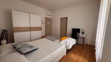 Een slaapkamer met een bed, een bureau en een stoel.