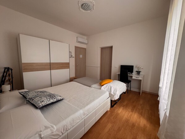 Un dormitorio con una cama, un escritorio y una silla.