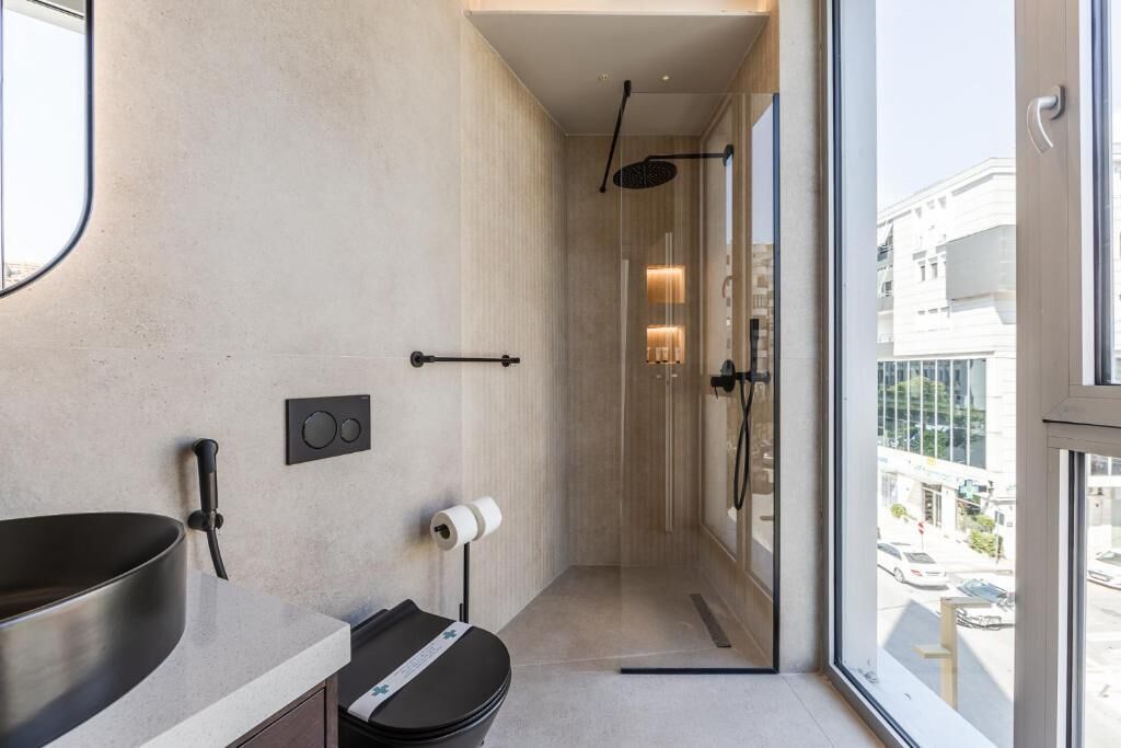 A modern bathroom with a large sink, toilet, and shower.
