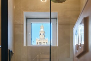 Blick auf ein Gebäude mit einem Uhrturm durch ein Fenster.