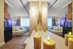 Ein modernes Wohnzimmer mit einer Couch, einem Esstisch mit Kerzen und einer Stadtansicht an den Wänden.