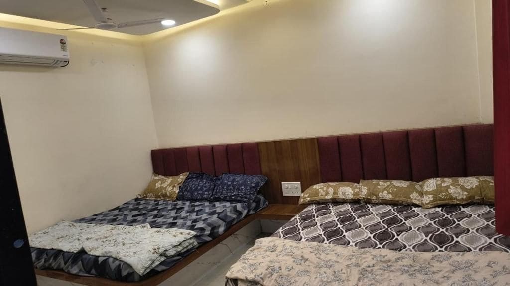 Een hotelkamer met een bed, nachtkastje en een airconditioning.