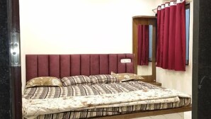 Ein Schlafzimmer mit einem Bett, einem Deckenventilator und einem Fenster mit Vorhängen.