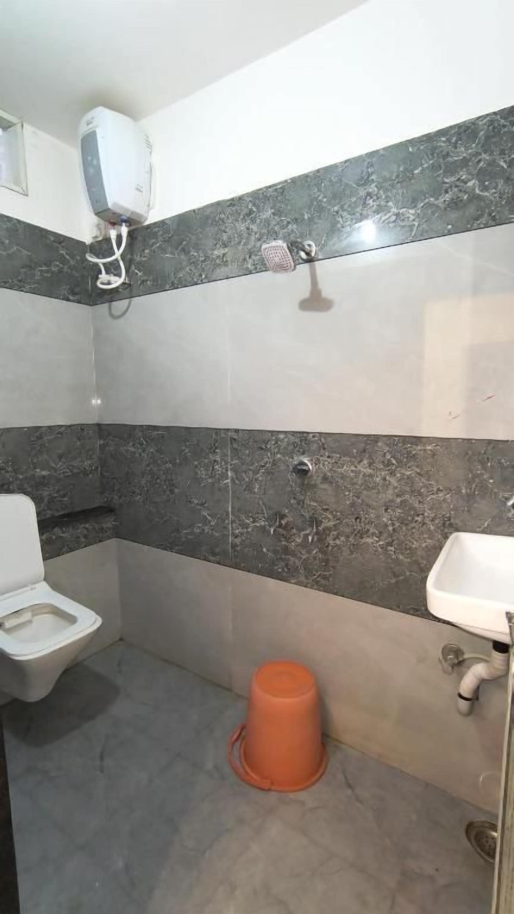 A bathroom with a toilet, sink, and shower.