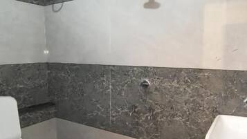 A bathroom with a toilet, sink, and shower.