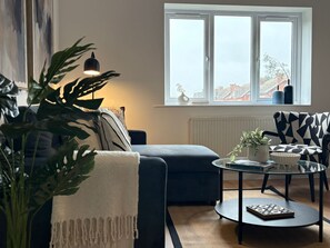 A living room with a sofa, a coffee table, and a potted plant. - 2-Bed, 2-Bath Near Birkdale Golf Club - Flat 5 (Southport)