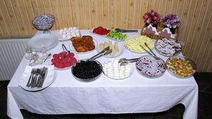 A buffet table with various food items and utensils.