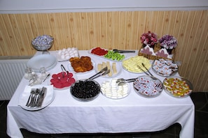 A buffet table with various food items and utensils.