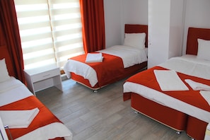 A hotel room with three beds, each with white linens and orange bedding. - BATIN OTEL (Karabük)