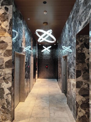 A hallway with marble walls and a geometric light fixture. - TOWER HOTEL (FUKUOKASHI/HAKATAKU/REISENMACHI)