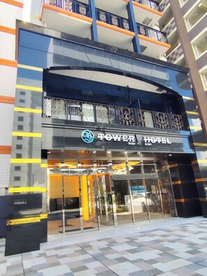 A hotel entrance with a glass facade, a sign reading 'POWER HOTEL', and a balcony with ornate railings. - TOWER HOTEL (FUKUOKASHI/HAKATAKU/REISENMACHI)