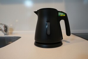 Een zwarte elektrische waterkoker op een aanrecht.
