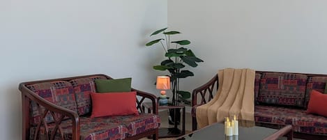 A living room with a sofa set, a coffee table, a floor lamp, and a ceiling fan.