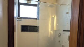 A bathroom with a shower, a toilet, and a sink.