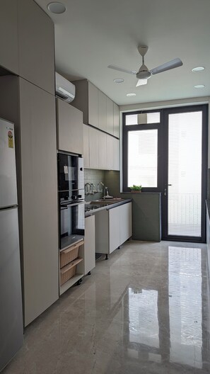 Une cuisine moderne équipée d’un four, d’un micro-ondes et d’un évier encastrés.