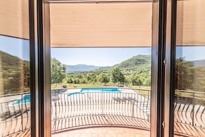 A balcony with a pool, offering a view of a mountainous landscape.