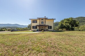 A two-story building with a flat roof, a small porch, and a clear view of the surrounding landscape.