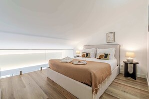 A modern bedroom with a large bed, bedside lamps, and a view through a window. - Stylish Flat Near the Douro River by HostWise (Vila Nova de Gaia)