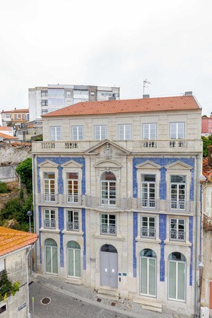 A multi-story building with a tiled roof, large windows, and a central entrance. - Stylish Flat Near the Douro River by HostWise (Vila Nova de Gaia)