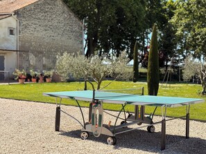 A portable ping pong table with wheels, set up outdoors on gravel. - Le Tournesol - Laforest Estate Vacation Rental (Fontvieille)