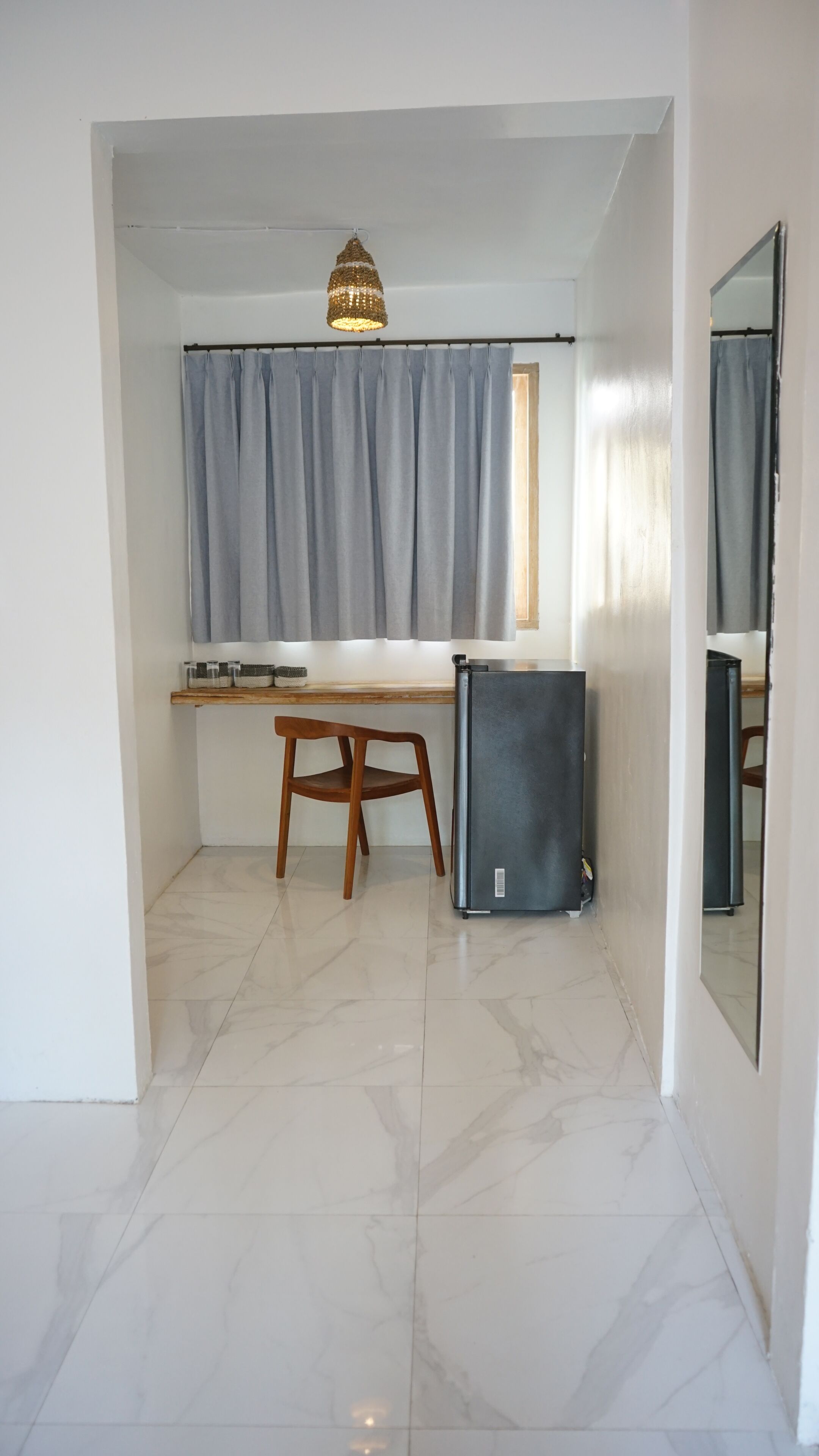 Una habitación compacta con escritorio, silla y refrigerador.