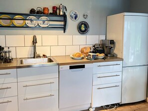A modern kitchen with a dishwasher, a coffee maker, and a refrigerator. - 5 Star Holiday Home in Knared (Knared)
