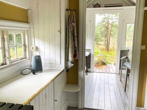 A room with a window, a kettle, a chair, and a door leading to an outdoor area. - 5 Star Holiday Home in Knared (Knared)