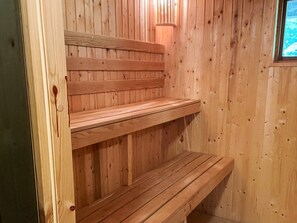 A wooden sauna with benches and a wall-mounted light fixture. - 5 Star Holiday Home in Knared (Knared)