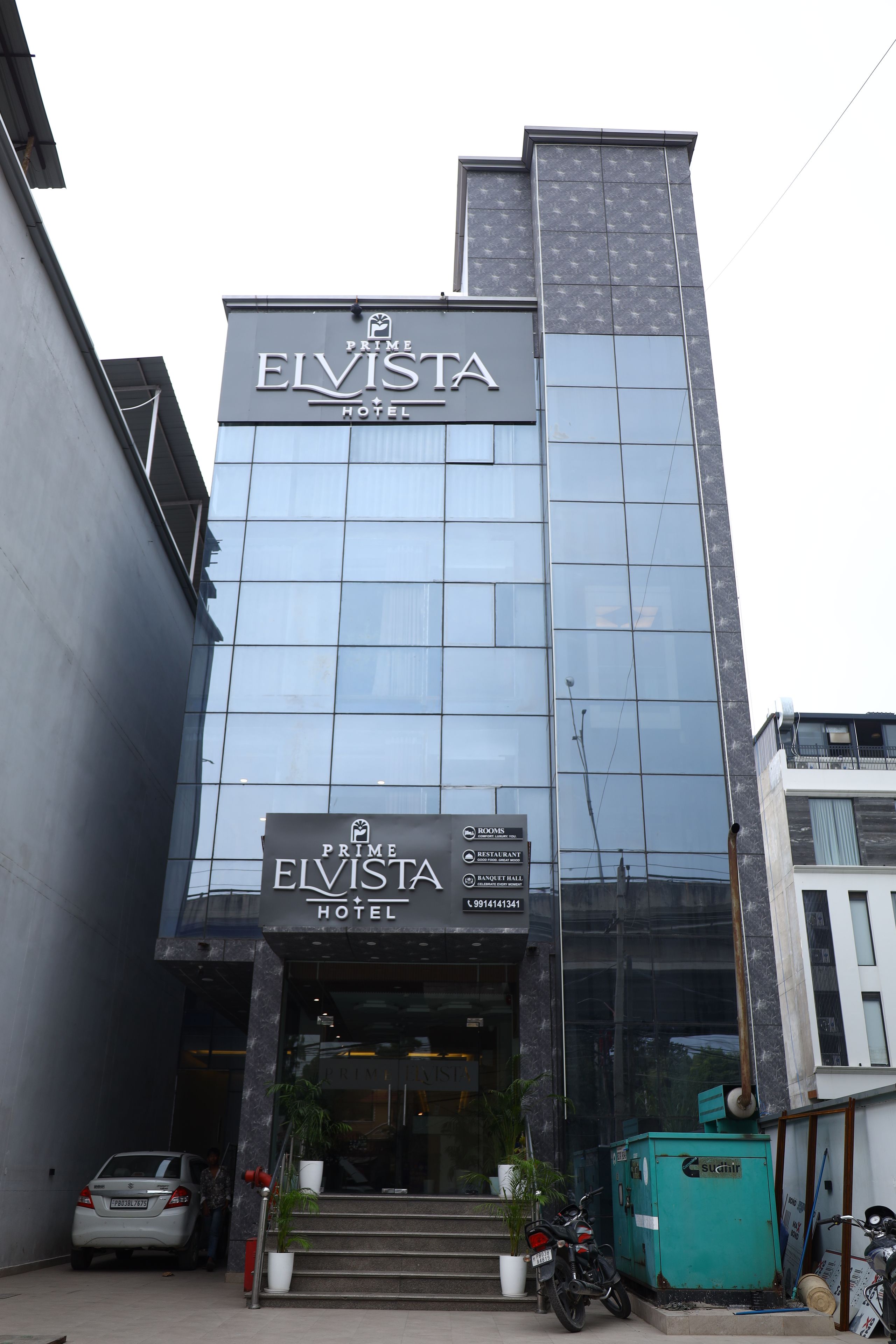 Un hotel con fachada moderna, un letrero llamativo y una escalera que conduce a la entrada.