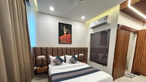 Quarto de hotel moderno com cama, mesa de cabeceira, janela e ar condicionado.
